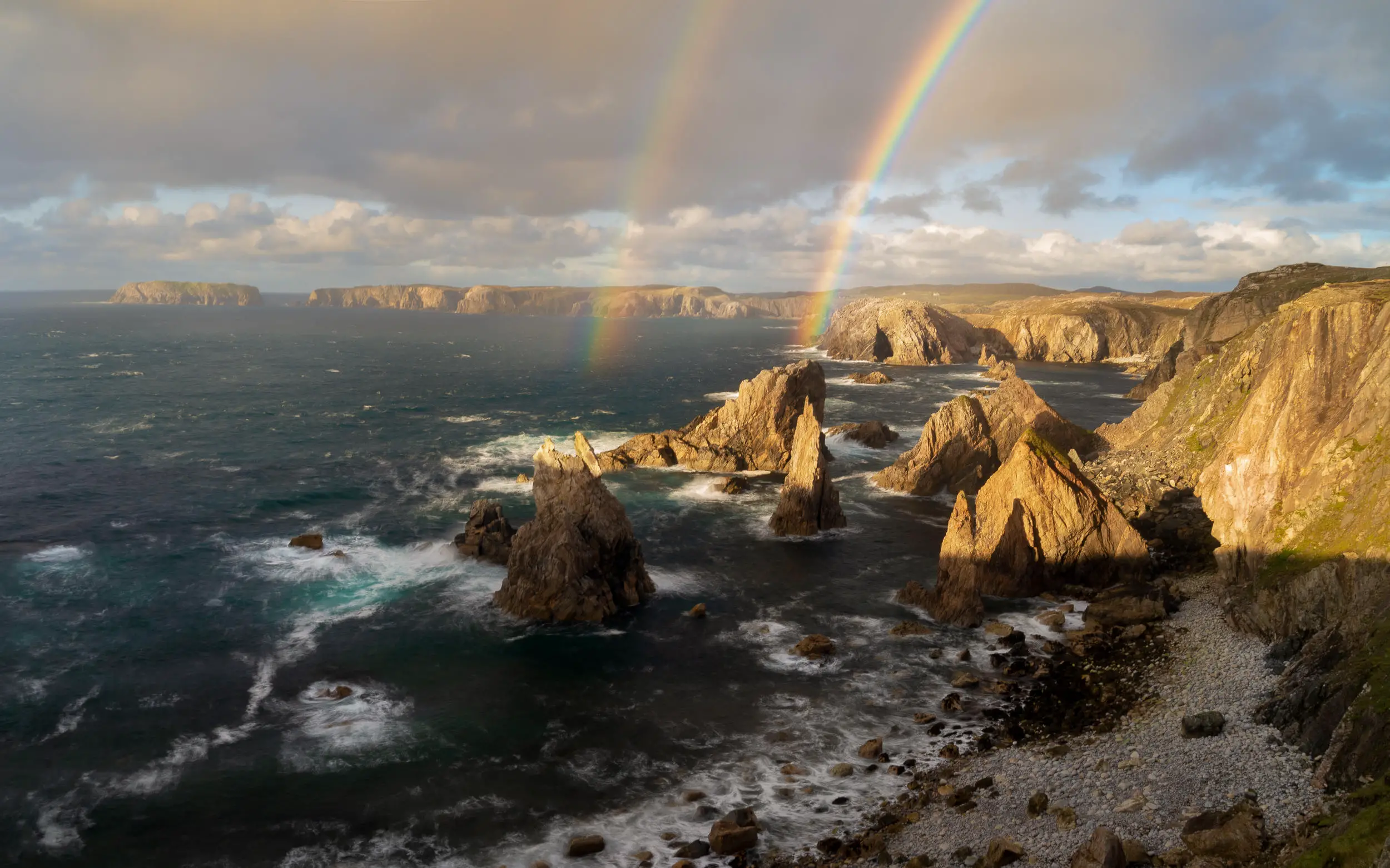 Les arcs-en-ciel sortent des côtes rocheuses de l'île de Lewis en Écosse. Le photographe Richard Fox écrit : 
