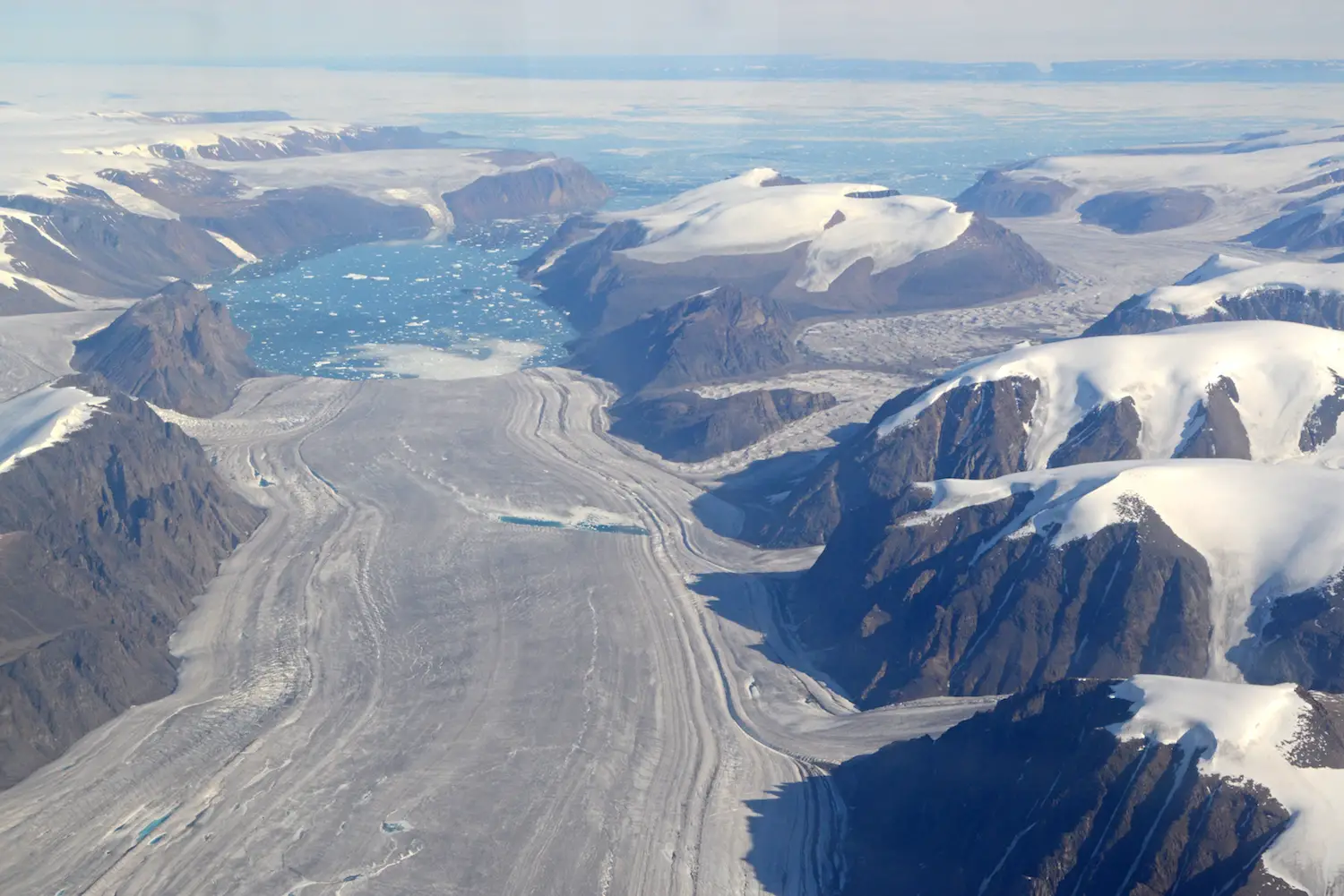 Une plate-forme de glace marine sur le bord est du champ de glace Prince of Wales, au centre-est de l'île d'Ellesmere, au Nunavut, au Canada, produit des icebergs et des étangs d'eau de fonte. Les icebergs qui se détachent de ces plates-formes de glace pourraient éventuellement dériver vers le sud dans la baie de Baffin.