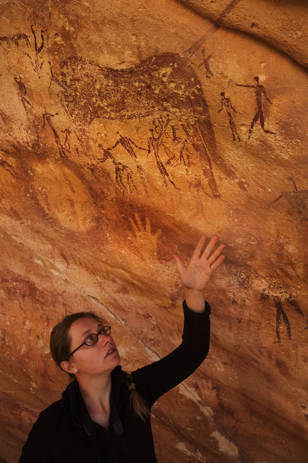 Emmanuelle Honoré lève la main dans la grotte Wadi Sūra II, située dans la partie égyptienne du désert libyen.
