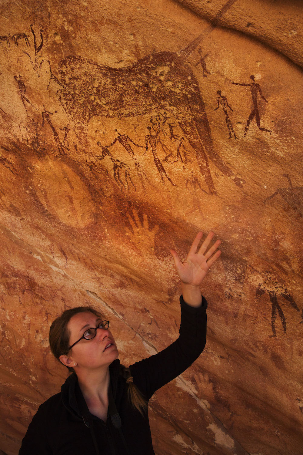 Emmanuelle Honoré lève la main dans la grotte Wadi Sūra II, située dans la partie égyptienne du désert libyen.