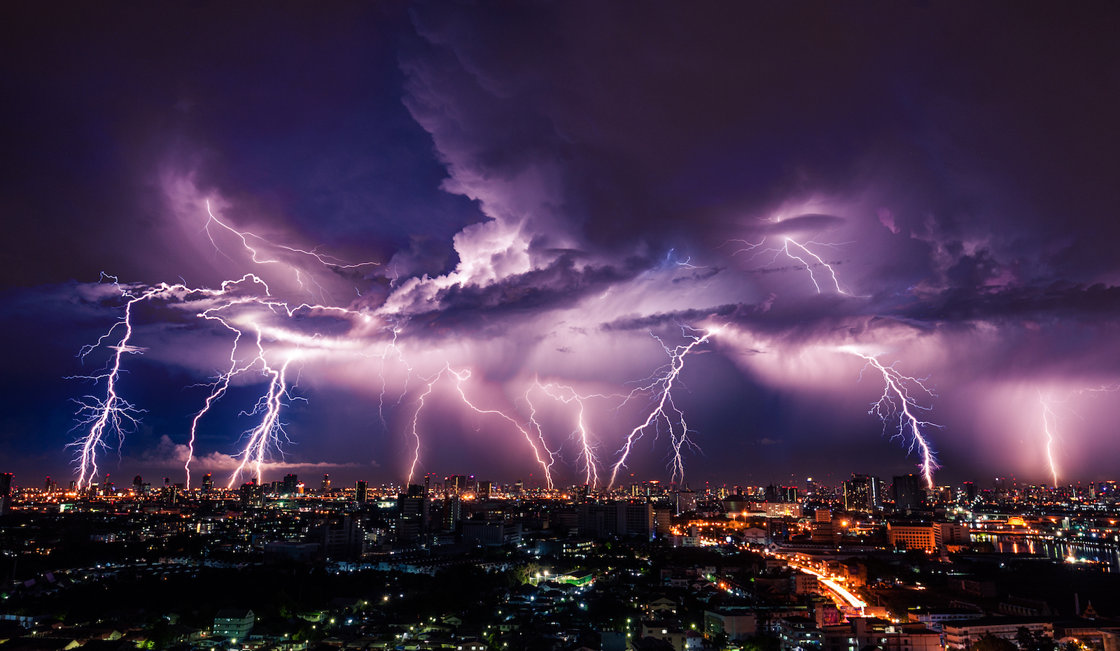 éclairs sur une ville au ciel violet