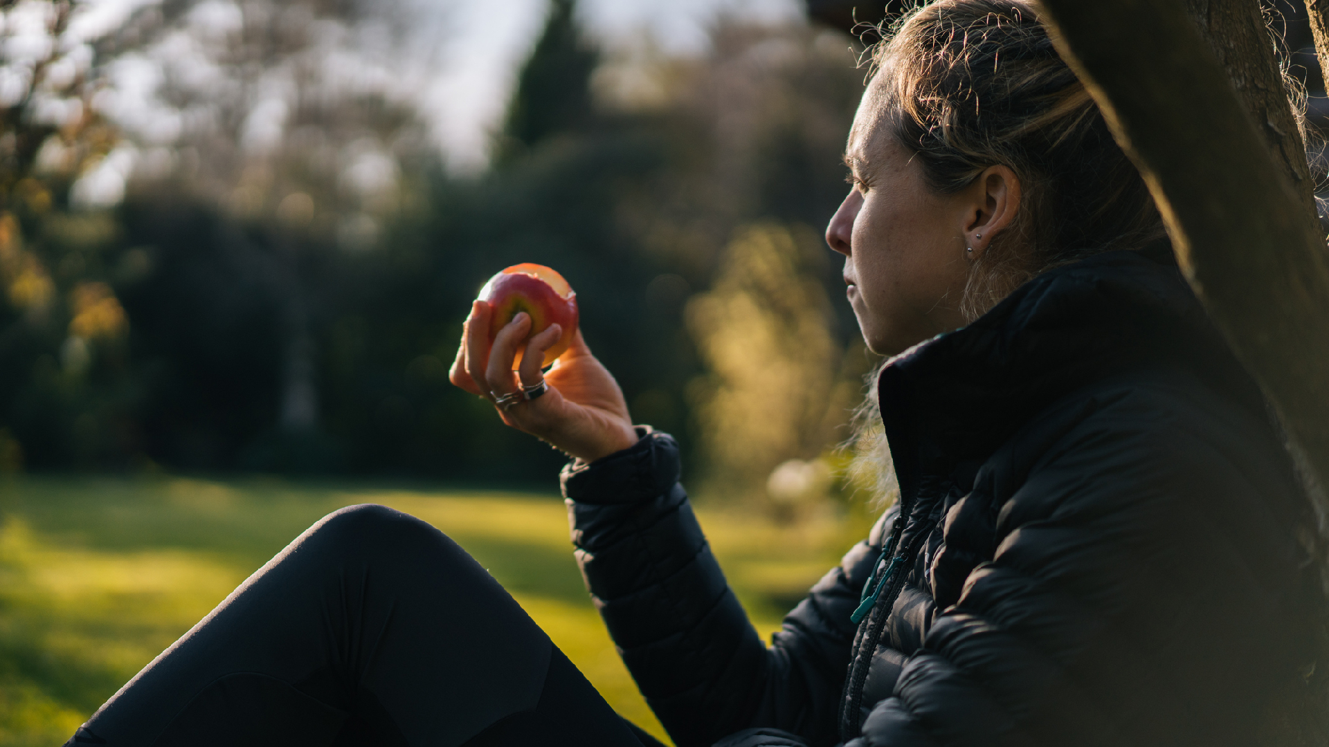 femme mangeant une pomme en regardant la nature