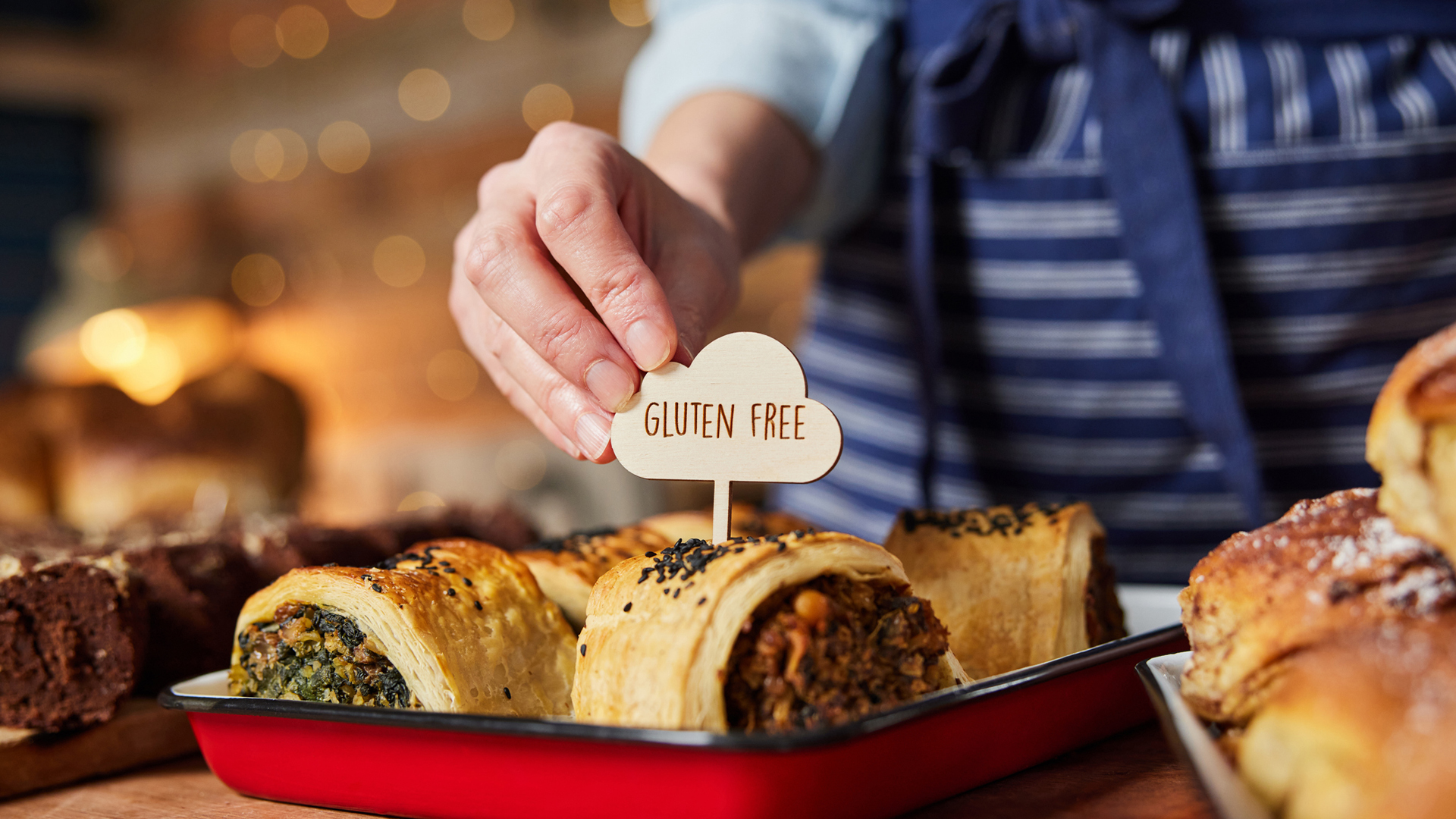 boulanger proposant des rouleaux de saucisses sans gluten